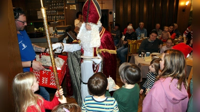 Der Hl. Nikolaus (Werner Kirschner) spricht mit den Kindern und verteilt kleine Geschenke bei der Adventsfeier der Siedlergemeinschaft Feuerhof (Bild: Anton Fenk)