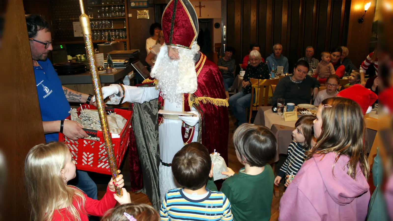 Der Hl. Nikolaus (Werner Kirschner) spricht mit den Kindern und verteilt kleine Geschenke bei der Adventsfeier der Siedlergemeinschaft Feuerhof (Bild: Anton Fenk)