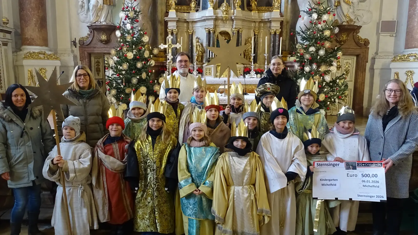 Die Michelfelder Sternsinger spendeten 500 Euro für den örtlichen Kindergarten. Dessen Leiterin Christine Sporrer (rechts) nahm den symbolischen Scheck entgegen. Diakon Franz-Josef Reck (hinten links) dankte den Organisatorinnen Maria Hofmann und Mirjam Wallner (von links) und ehrte Pauline Meier (hinten rechts) für ihre zehnte Teilnahme am Sternsingen.  (Bild: Markus Müller)