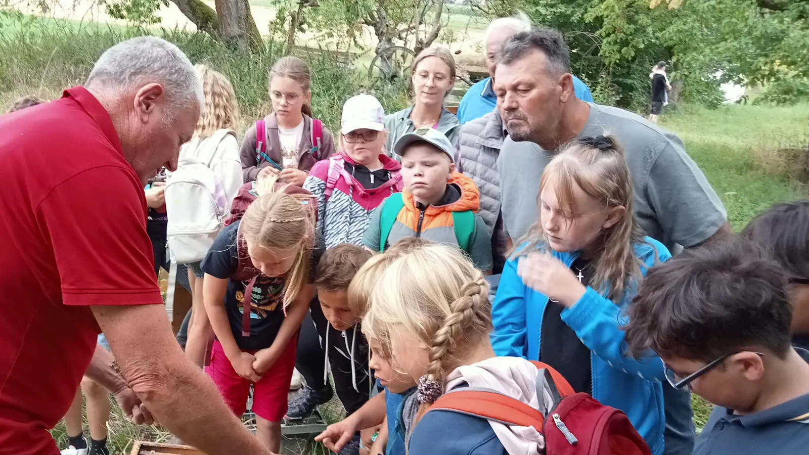 Imker und Senior - Chef Josef Ernst erläuterte den interessierten Besuchern des Konnersreuther Ferienprogramms die Arbeitsweise und das Innenleben eines Bienenstocks und in diesem Zusammenhang die Arbeitsschritte des Imkerwesens zur Gewinnung von Bienenhonig.  (Bild: Max Bindl)