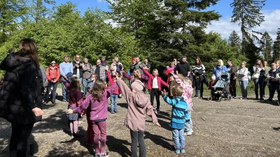 Mitten im Wald singen die Kinder Lieder und tanzen für ihre Mütter und Väter. (Bild: Anja Thalhauser)