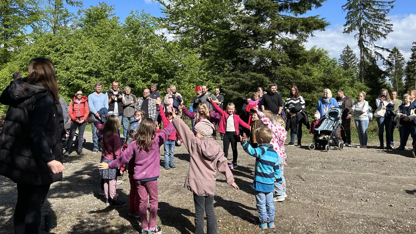 Mitten im Wald singen die Kinder Lieder und tanzen für ihre Mütter und Väter. (Bild: Anja Thalhauser)