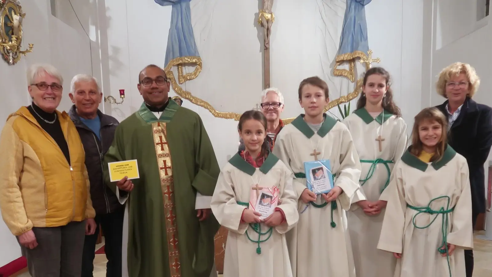 Zuschuss-Übergabe zur Orgelrenovierung in der Kreuzbergkirche. (Von links): Veronika Pröls, Mesner Christian Weiß, Pfarrvikar Pater Jimmy Joseph, Kreuzbergministranten, Ladenmitarbeiterinnen Elfriede Kredler und Gudrun Quarder. (Bild: Rosi Hasenstab)