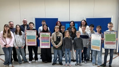 Schülerinnen und Schüler, Rektorin Silke Schmid, Bürgermeister Richard Tischler und Hausmeister Markus Muntanjohl mit den neu ausgearbeiteten Hausordnungen der Grund- und Mittelschule Pfreimd. (Bild: Jasmin Ulrich)