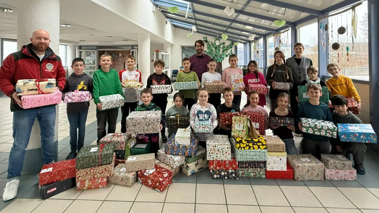 Die Kinder der Klasse 4a übergaben 80 Päckchen für bedürftige Kinder in Osteuropa an Benedikt Gruber (links) von Round Table (Bild: Elfriede Weiß)