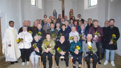 Mit Sonnenblumenstrauß und Fairtrade-Schokolade gratulierte der Pfarrgemeinderat den Kommunionjubilaren. (Bild: Siegfried Bock)