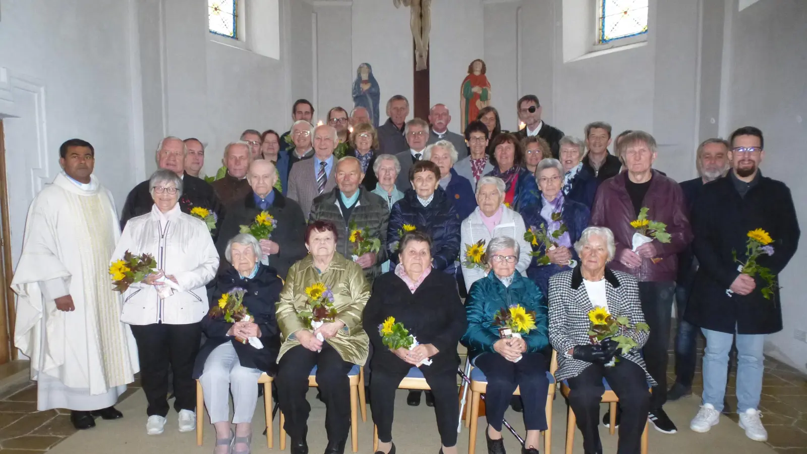 Mit Sonnenblumenstrauß und Fairtrade-Schokolade gratulierte der Pfarrgemeinderat den Kommunionjubilaren. (Bild: Siegfried Bock)