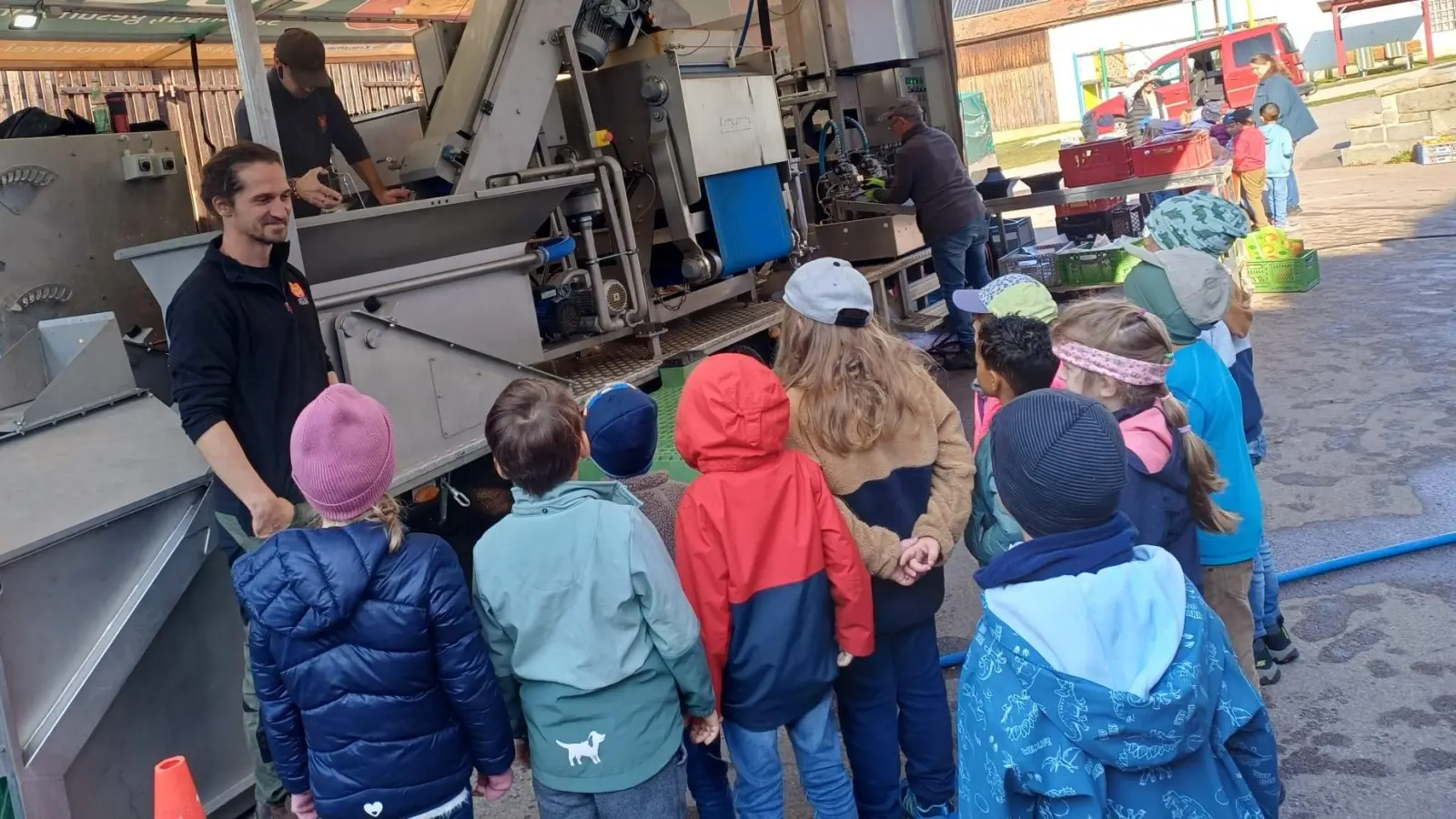 Aufmerksam verfolgen die Kindergarten Kinder des St. Jakobus Ensdorf, wie beim Pressvorgang aus frischen Äpfeln köstlicher, naturtrüber Apfelsaft entsteht. Dabei erleben sie hautnah, wie regionale Lebensmittel verarbeitet werden. (Bild: Manuela Mayer)