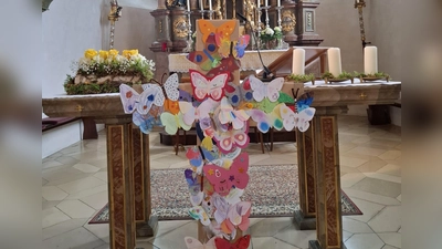Aus einem dunklen Kreuz, das Zeichen von Leid und Tod wurde Schritt für Schritt mit dem Befestigen der bunten Schmetterlinge ein farbenfrohes Symbol der Osterfreude (Bild: Denise Lang)