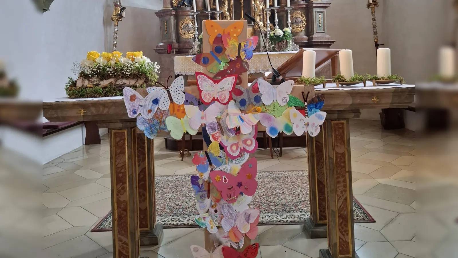 Aus einem dunklen Kreuz, das Zeichen von Leid und Tod wurde Schritt für Schritt mit dem Befestigen der bunten Schmetterlinge ein farbenfrohes Symbol der Osterfreude (Bild: Denise Lang)