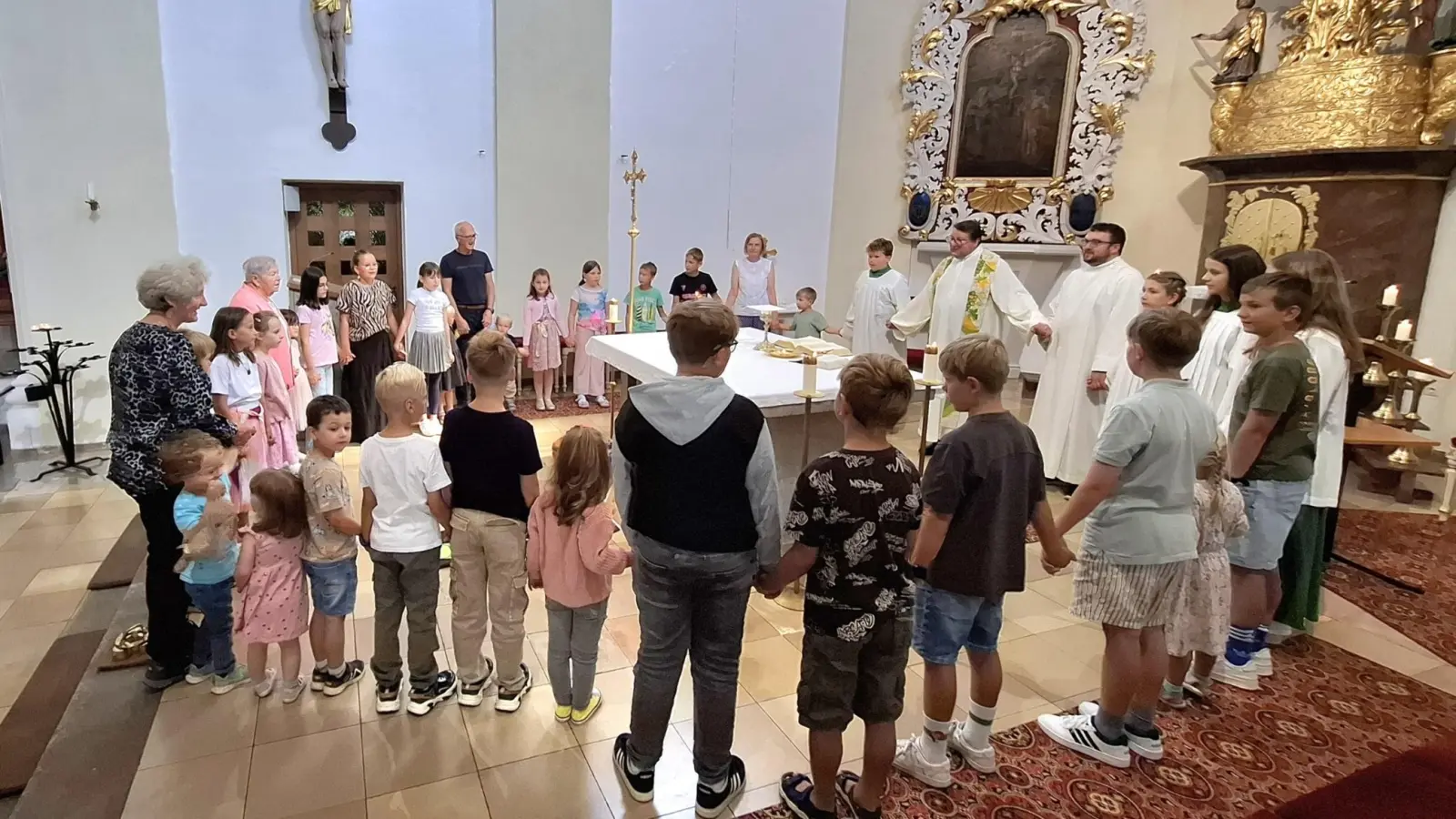 Beim Vaterunser versammelten sich Pfarrer Udo Klösel und Gemeindereferent Benedikt Eckert mit Großeltern und Enkeln um den Altar.  (Bild: Karl Ziegler)