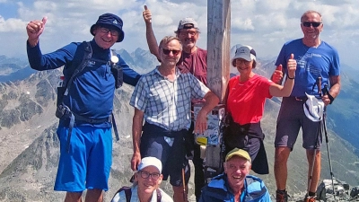 Foto: Birgit Schelter und Josef Kunz (vorne) und Tourenführer Rainer Rahn, Bernhard Goldmann, Günter Reul, Karin und Anton Hollmann (hinten von links) am Gipfelkreuz des Schwarzhorn. Tief unten der Flüelapass.  (Bild: Rainer Rahn)