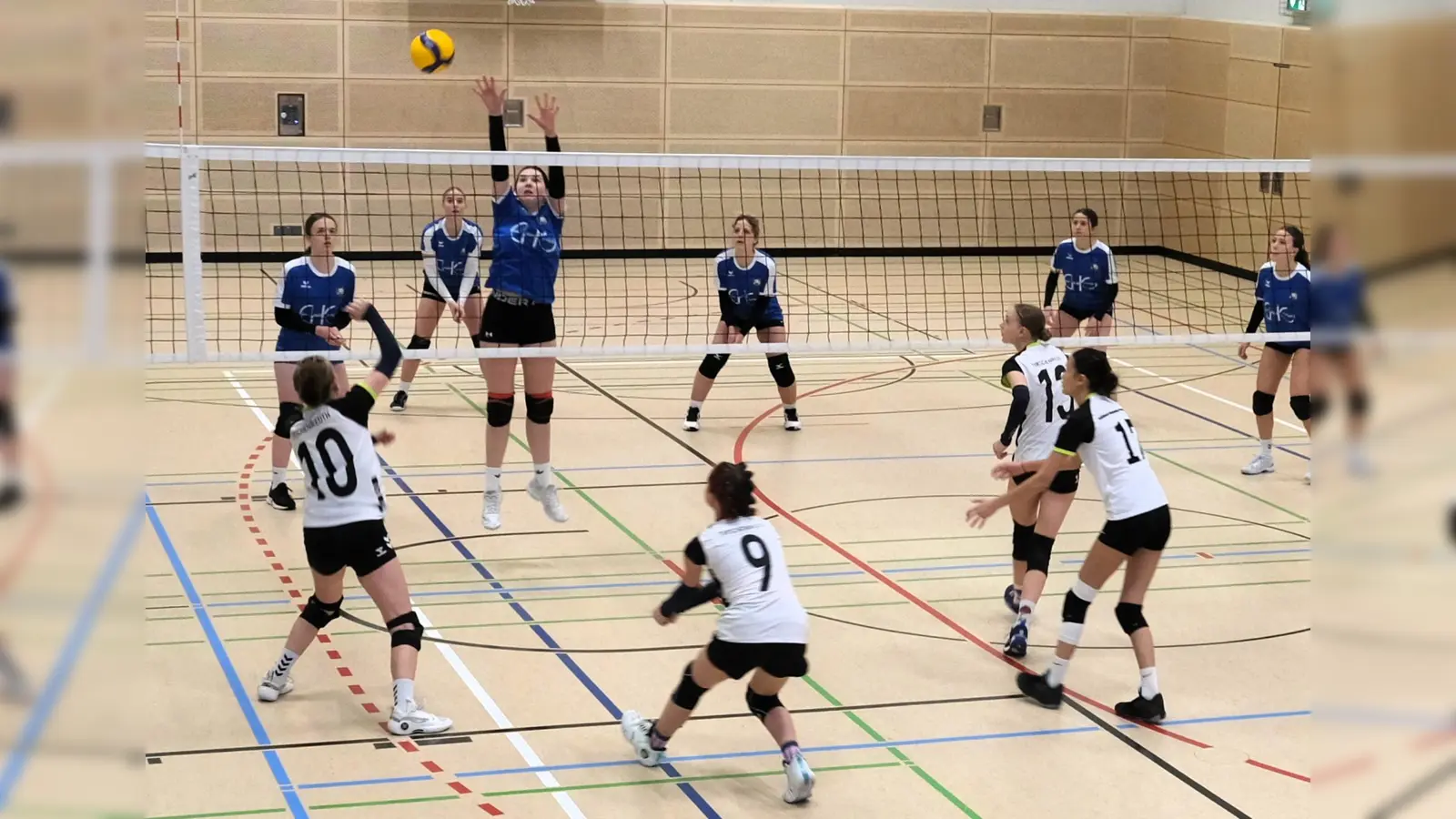 Gruppenspiel des Elly-Heuss-Gymnasiums Weiden in blau gegen das Stiftland-Gymnasium Tirschenreuth in weiß beim U18-Volleyball-Regionalentscheid der Schulen 2026 in Tirschenreuth. (Bild: Martin Putzlocher)