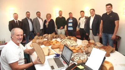 Brotprüfer Manfred Stiefel (sitzend) bewertete die Produkte der teilnehmenden Innungsbetriebe. Das Bild zeigt von links: Obermeister Marcel Morawe, Kreishandwerksmeister Florian Danzl, Geschäftsführer der Handwerkskammer Niederbayern-Oberpfalz Alexander Stahl, Claudia Mendel, Marcel Morawe und Helmut Kosler, Kurt Scherl, Christian Glaab, Lorenz Scheitinger. Bild: Hirsch (Bild: Rudi Hirsch )