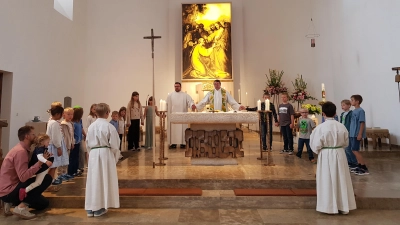 <br>„Gott lässt sein Reich mit uns wachsen“. Unter diesem Thema stand der Familiengottesdienst. Zum Vaterunser stellten sich die Mädchen und Buben mit Pfarrer Klösel und dem Gemeindereferenten Eckert mit um den Altar. (Bild: Peter Garreiss)
