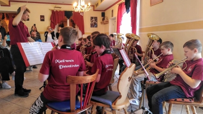 Jürgen Lößl dirigiert die Bläserklasse souverän durch ihr Repertoire. Die Fans der Nachwuchsmusiker filmen.  (Bild: Jasmin Brandl)