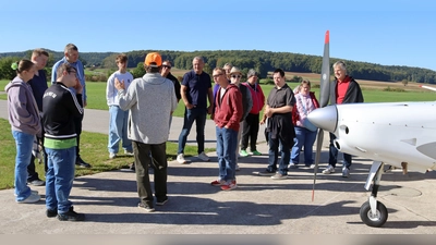 Peter Ostermann von der Luftsportgruppe (oranges Käppi) begrüßte die Gäste und Vertreter der Vereine und erklärte ansxhließend die Flugzeuge, die in Fichtelbrunn stationiert sind. (Bild: Heidi Franitza)