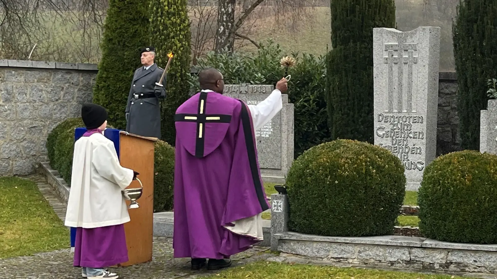 Pfarrer Emmanuel Okoro gedachte der Toten der Weltkriege und segnete das Ehrenmal am Unterauerbacher Friedhof. Die SKK Auerbachtal hatte die Feier vorbereitet. (Bild: Franz Grabinger)