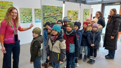 Die Tännesberger Grundschüler haben einen Blick für die Blumenbilder von Katharina Gierlach, die sich über den Besuch der jungen Ausstellungsgäste im Oberviechtacher Kulturzentrum freut. (Bild: Georg Lang)