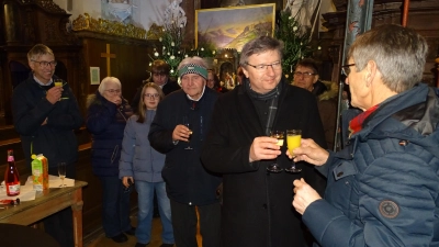 Beim Neujahrsempfang der Pfarrei Michelfeld stieß man auf ein gutes Jahr 2026 an, aber auch auf den 63. Geburtstag von Ortspfarrer Markus Flasinski (Zweiter von rechts). Erwin Holl (rechts) gratulierte im Namen der Pfarrgemeinde.  (Bild: Markus Müller)
