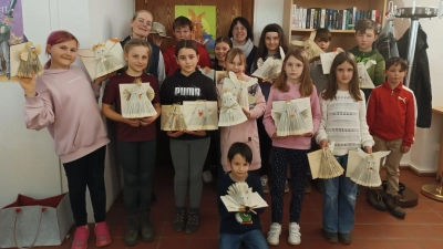 Stolz zeigen die Kinder die Ergebnisse des Workshops. Hinten links Büchereileiterin Maria Klobes-Martin, rechts Expertin Christine Simmel. (Bild: Christine Simmel)