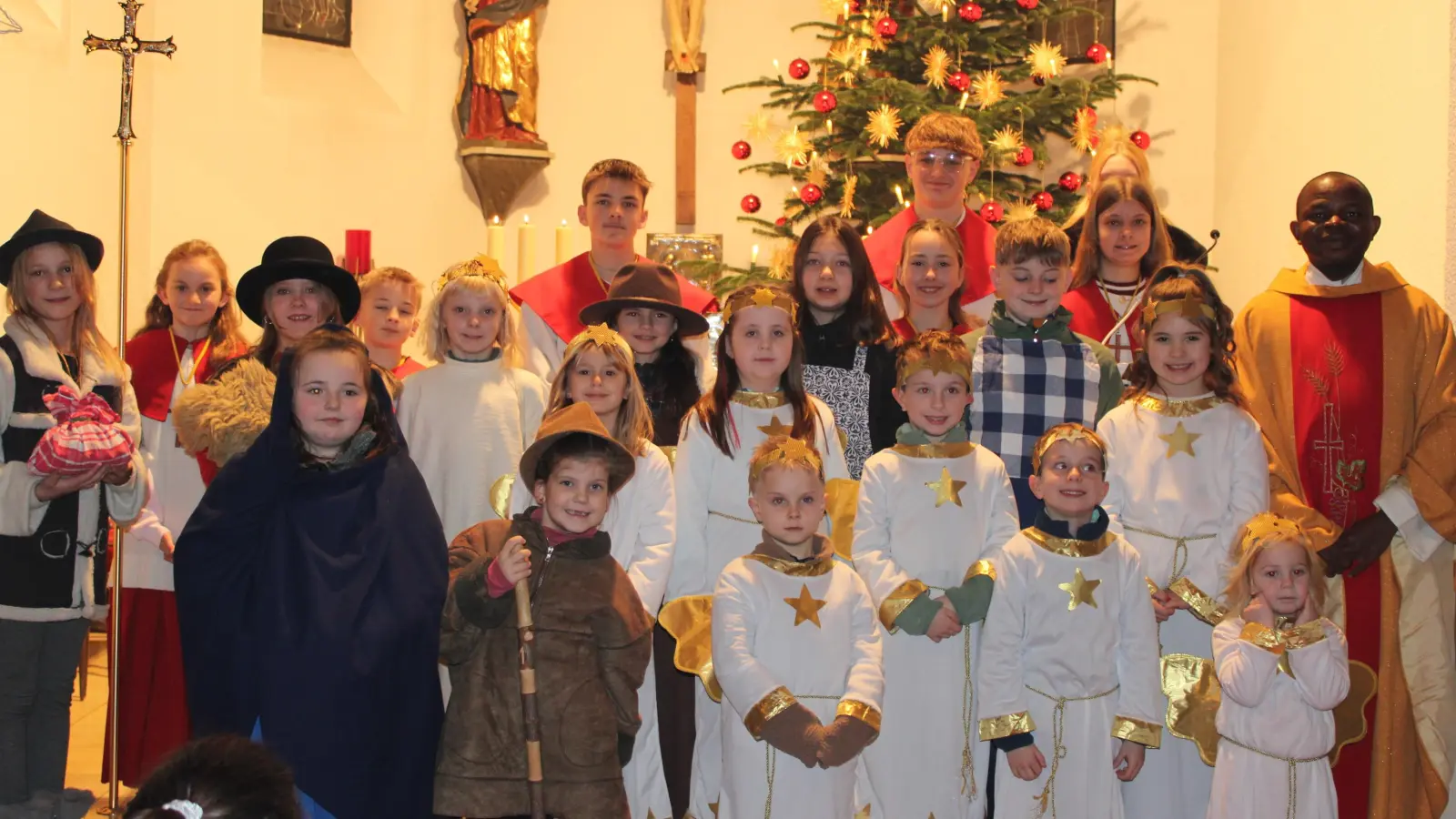Kinder vom Krippenspiel, Ministranten und Pfarrvikar Luke Eze. (Bild: Rosemarie Ernst)