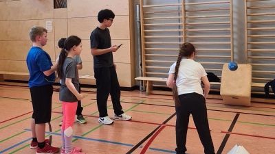 Die Pestalozzi-Schüler üben unter Anleitung eines HCA-Gymnasiasten das präzise Werfen des Balles auf ein Ziel (Bild: Lisa Steiner)