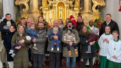 Die Täuflinge der Jahre 2024 und 2024 der Pfarrei Rottendorf mit ihren Eltern und Geschwistern sowie Pfarrvikar Placide Kabamba und dem Pfarrgemeinderatssprecher Werner Schönberger (rechts) vor dem Hauptaltar der Pfarrkirche. (Bild: Karlheinz Hofmann)