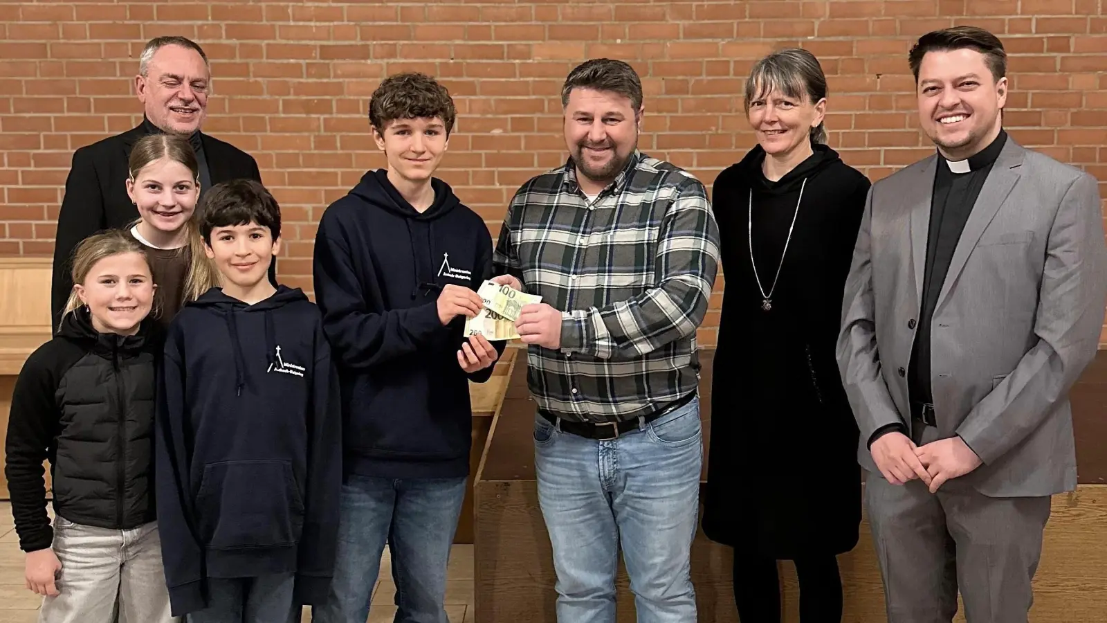 Auf dem Bild zu sehen sind Daniel Müller als Organisator der Spendenaktion (MItte) , Ministrantinnen und Ministranten aus Aschach-Raigering sowie Pfarrer Josef Irlbacher, die Sprecherin des PGR Kerstin Püschl sowie Kaplan Marvin Schwedler . (Bild: Alfred Schorner)