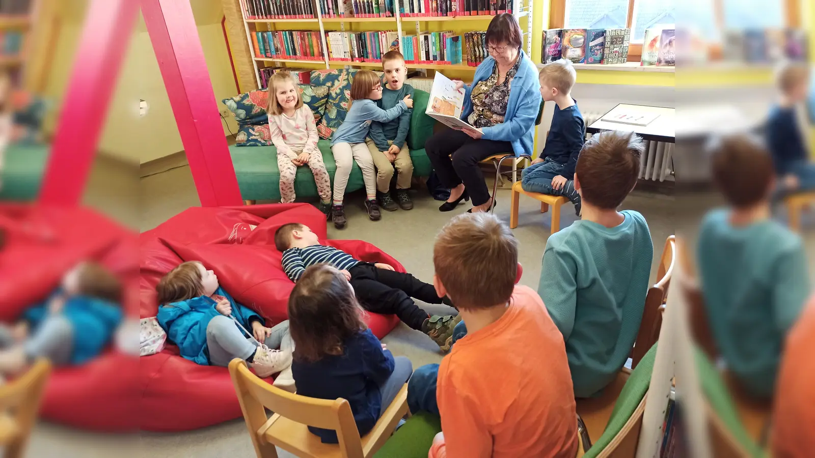 Die jungen Zuhörer haben es sich rund um die Lesepatin Carola Wittek bequem gemacht.  (Bild: Heike Hagl)
