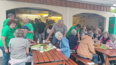 Beim Weinfest der Krumpes-Siedler war das Gerätehaus von Anfang an voll besetzt. Nachdem sich der Regen verzogen hatte, füllten sich auch die Bänke, die auf dem Vorplatz für die weiteren Gäste aufgestellt worden waren.  (Bild: Hubert Lukas)