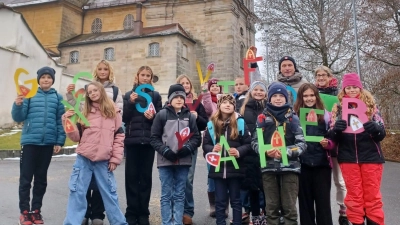 Die Schüler der Klasse 5a, begleitet von Studienrätin (MS) Felicitas Berger und Schulleiter Florian Fuchs, bereicherten die Eröffnung des forstlichen Weihnachtsbasars auf dem Mariahilfberg mit dem „Nikolaus-ABC” von James Krüss.  (Bild: Florian Fuchs)