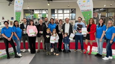 Vorsitzende Anne Wagner (Bildmitte mit blauem Polohemd) freute sich, in der Wagner-Oldtimer-Galerie zusammen mit ihren Vereinsmitgliedern (alle in blauen T-Shirts) viele „Motorwelten”-Preise an die Gewinner übergeben zu können; das Bild zeigt von links Michaela Sperl, Nevin Yerlikaya, Dominik Obermeier (O.S.A.), Gabi Farnbauer, Alexander Granberg (Auto Fischer), Mateusz Osicki (O.S.A.), Anne Wagner, Winfried Osicki (O.S.A.), Selina und Alexander Riemer, Thomas Gräml, Sandra Winter (Bausanierung-BZ) und ganz rechts Kirsten Prax. (Bild: Thomas Amann)