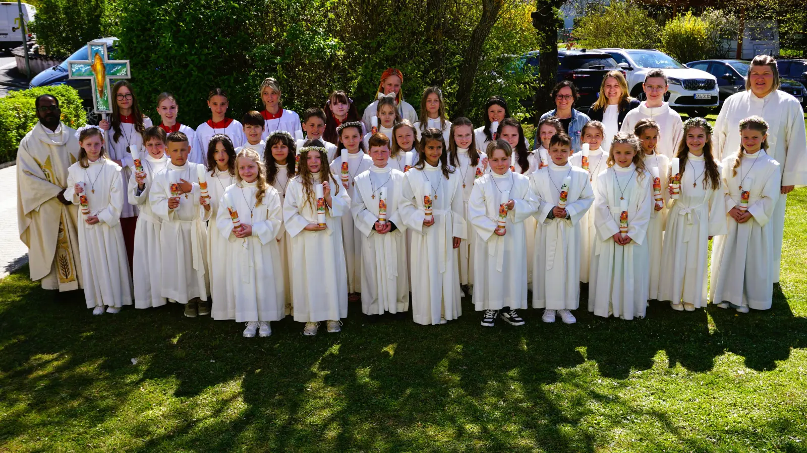 Die 27 Erstkommunionkinder aus der Pfarreiengemeinschaft Theuern-Ebermannsdorf / Pittersberg nach ihrem Festgottesdienst in der Bruder-Konrad-Kirche. Links hinten Pfarrer Sagai, rechts die Gemeindereferentin Kathrin Blödt, mit ihrer Assistentin, Sarah Koch, sowie den Religionslehrerinnen der Kinder an den Schulen in Kümmersbruck und Ebermannsdorf. (Bild: Christine Wendl)