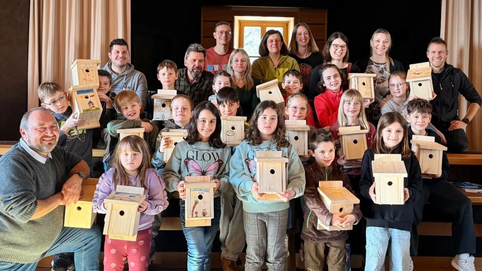 Stolz präsentieren die Kinder ihre selbst gebauten Nistkästen unter der Anleitung von Oliver Becher (links). (Bild: Johannes Koller)