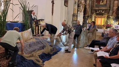 Der liebevoll dekorierte Altarraum in der Wallfahrtskirche St. Quirin mit Holzboot, Schilf und Binsen. Symbolisch wird dazu ein großes Fischernetz vor dem Altar ausgebreitet. (Bild: Franz Völkl)
