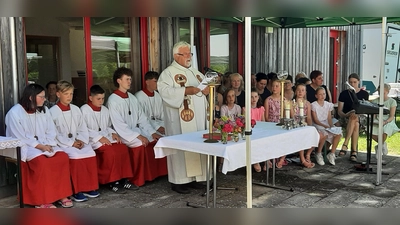 Pfarrer Arnold Pirner mit den Minis und dem Projektchor beim Open-Air-Gottesdienst zum Pfarrfest. (Bild: Rita Gleißner)