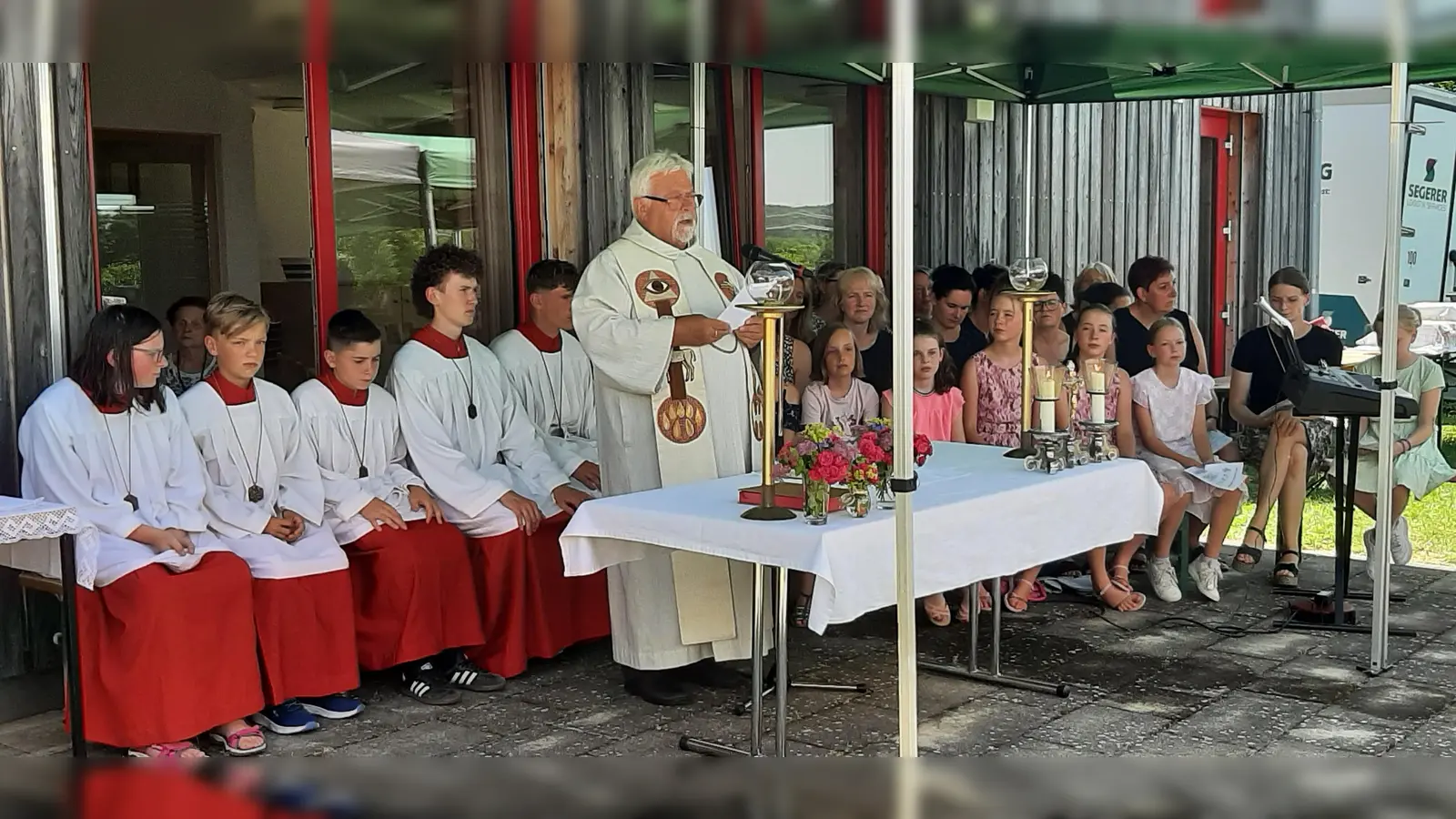 Pfarrer Arnold Pirner mit den Minis und dem Projektchor beim Open-Air-Gottesdienst zum Pfarrfest. (Bild: Rita Gleißner)