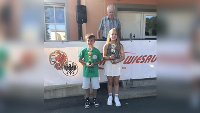 Die Besten beim ADAC Fahrradturnier des MSC Wiesau Leonard Schuller (Bester Junge) und Mia Fürnrohr (Bestes Mädchen). Im Hintergrund der Verkehrsreferent des MSC Wiesau Franz Negratschker Sen. (Bild: Karl-Heinz Dietrich )