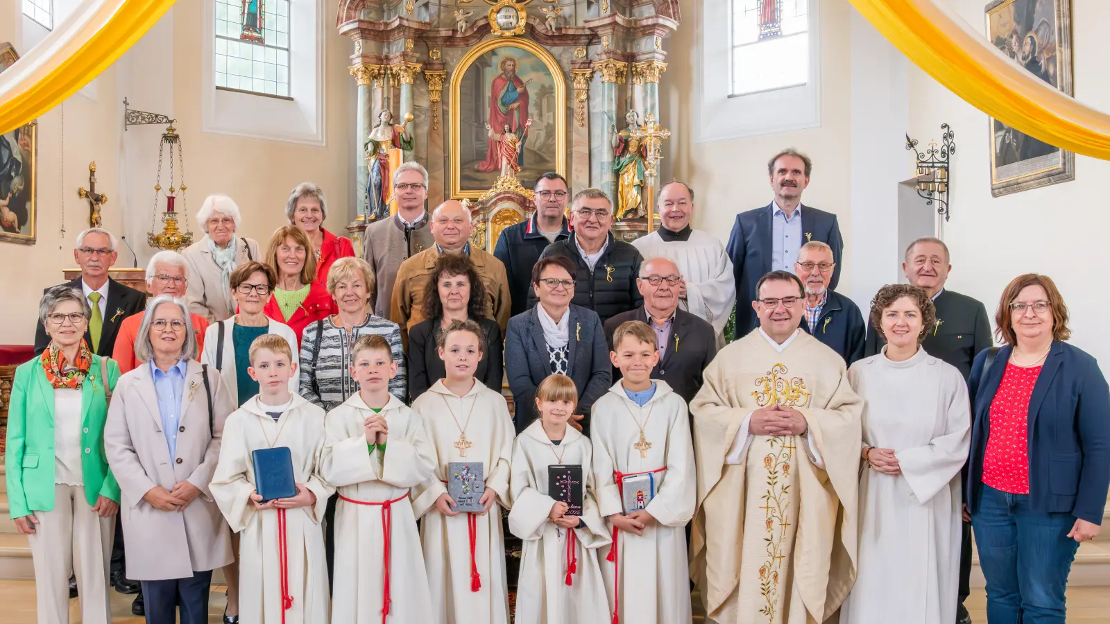 Auf dem Bild zu sehen: 19 Kommunion-Jubilare mit den 5 diesjährigen Kommunionkinder, Pfarrer Konrad Amschl, Pastoralreferentin Maria Wagner, Kommunionhelfer Tobias Franz, PGR-Sprecherin Theresa Meindl und Kirchenpfleger Marco Morgado (Bild: Wolfgang Schwamberger)